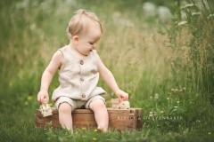 Baby boy playing with wooden truck during baby photography session Baby boy playing with wooden truck during baby photography session