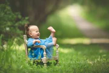 Baby girl kicking up her feet outside during her photography session