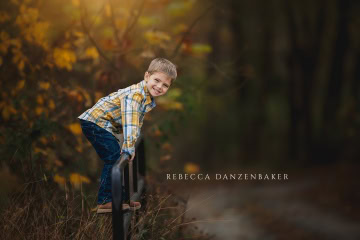 portrait of boy climbing a fence in the fall portrait of boy climbing a fence in the fall