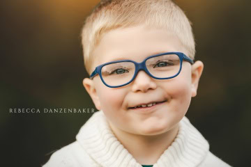photo of boy wearing glasses and smiling by Rebecca Danzenbaker