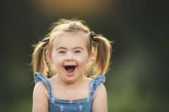 Girl with Down Syndrome smiling during a photo session with Rebecca Danzenbaker Girl with Down Syndrome smiling during a photo session with Rebecca Danzenbaker