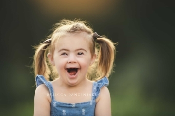Girl with Down Syndrome smiling during a photo session with Rebecca Danzenbaker Girl with Down Syndrome smiling during a photo session with Rebecca Danzenbaker