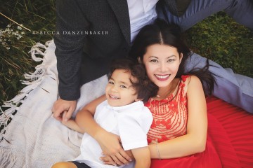 Boy and mom laying on dad's lap during a photo session with Rebecca Danzenbaker in Willowsford