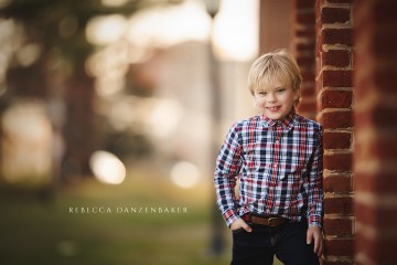 Boy standing by a brick wall in Fairfax VA during a family photography session