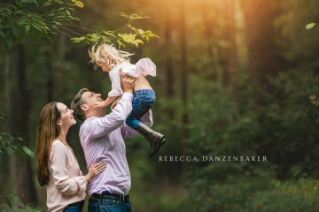 parents lifting toddler into the air