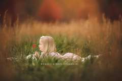 Portrait of girl laying in a field in November during a family photography session Portrait of girl laying in a field in November during a family photography session