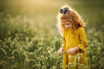 Girl standing in tall grass in September during Northern VA family photography session