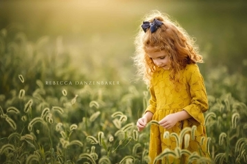 Girl standing in tall grass in September during Northern VA family photography session