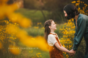Mother and daughter among yellow flowers Mother and daughter among yellow flowers