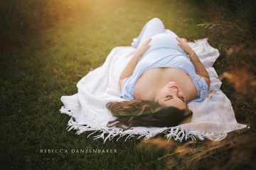 Sunset maternity portrait lying down with blue dress