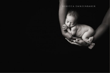 Baby sleeping in mother's arms newborn photography