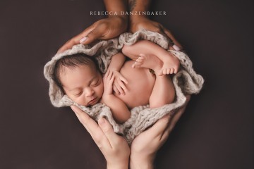 Newborn Baby being cradled in both parents' hands Newborn Baby being cradled in both parents' hands