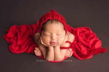 Newborn in froggy pose with smile