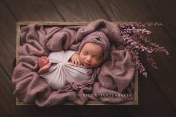 Newborn girl sleeping in purple props Newborn girl sleeping in purple props