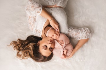 Newborn baby girl with mother in newborn photography studio