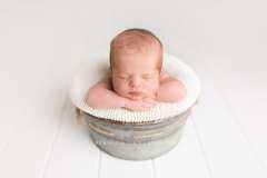 newborn baby in gray bucket newborn baby in gray bucket