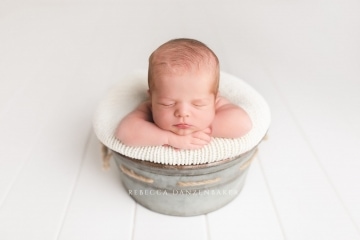 newborn baby in gray bucket