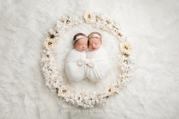 Twin newborn babies surrounded by flowers Twin newborn babies surrounded by flowers