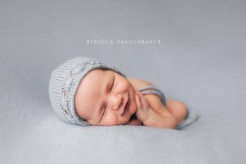 Smiling newborn baby on light blue blanket Smiling newborn baby on light blue blanket